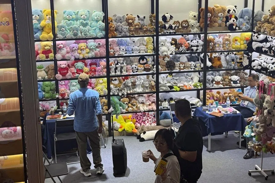 People walk past stuffed toys displayed at a booth during the China Import and Export Fair, commonly known as the Canton Fair, in Guangzhou, Guangdong province, China, on 31 October 2025. (David Kirton/Reuters)