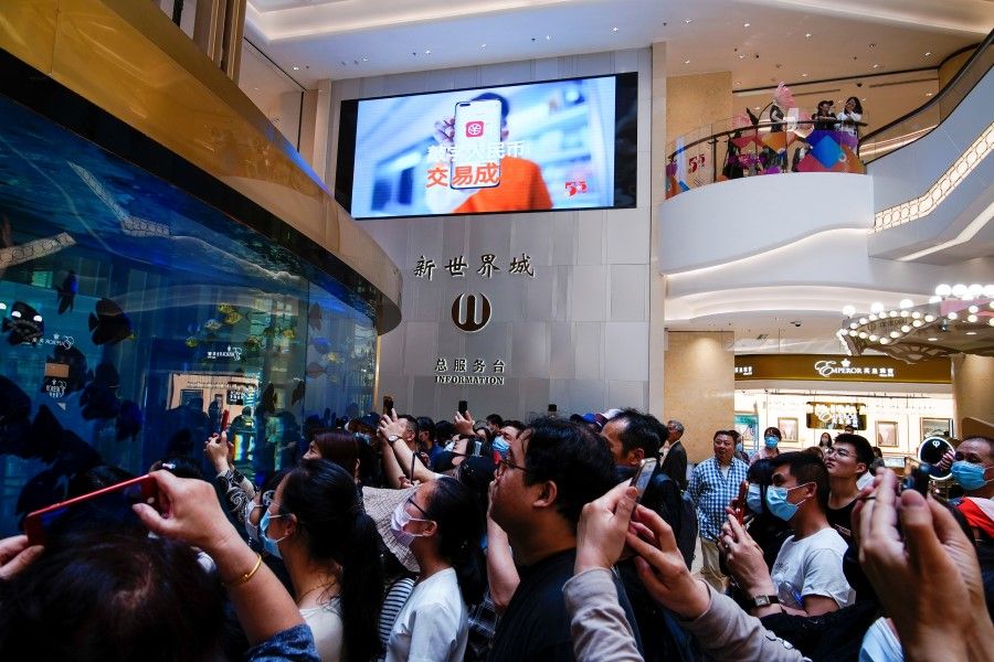 A sign indicating digital yuan, also referred to as e-CNY, is pictured on a big screen at a shopping mall in Shanghai, China, 5 May 2021. (Aly Song/Reuters)