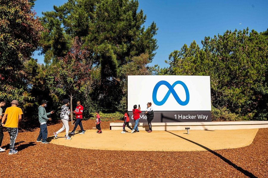 People visit a newly unveiled logo for "Meta", the new name for Facebook's parent company, outside Facebook headquarters in Menlo Park on 28 October 2021. (Noah Berger/AFP)