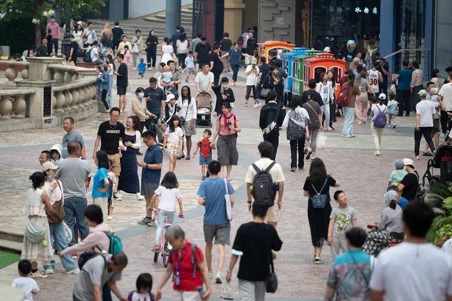 People walk through a shopping mall in Beijing, China, on 19 May 2024. (Greg Baker/AFP)