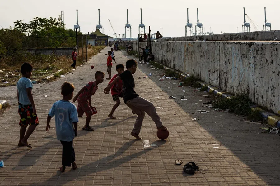 Children play football on a street beside a seawall in Jakarta on 9 August 2025. (Yasuyoshi Chiba/AFP)