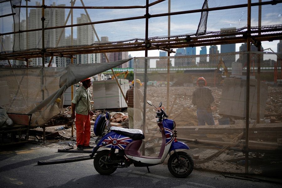 Workers work at a demolition site, following the Covid-19 outbreak, in Shanghai, China, 9 September 2022. (Aly Song/Reuters)