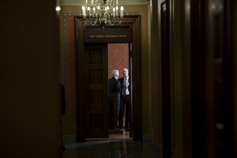 Senate Minority Leader Mitch McConnell speaks with Senator Rick Scott before a meeting with Republican Senators on their party's plan for the vote on the debt limit at the US Capitol on 7 October 2021 in Washington, DC. (Anna Moneymaker/AFP)