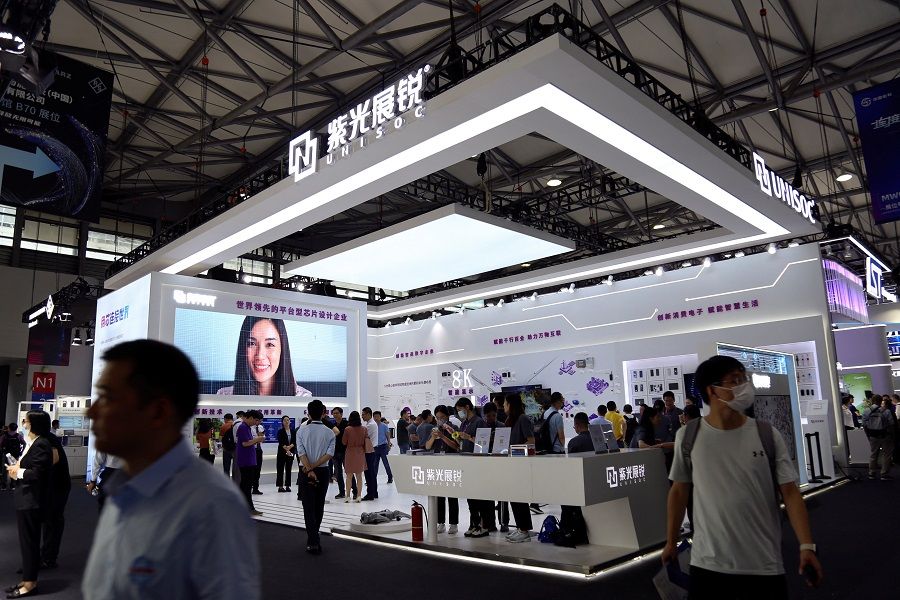 Visitors walk past the booth of chip design company Unisoc during the Mobile World Congress in Shanghai, China, on 28 June 2023. (Nicoco Chan/Reuters)
