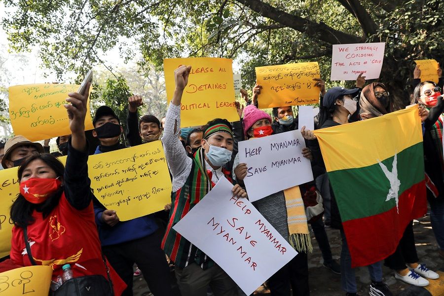Myanmar citizens living in India hold placards and shout slogans during a protest against the military coup in Myanmar, in New Delhi, India, 5 February 2021. (Anushree Fadnavis/Reuters)