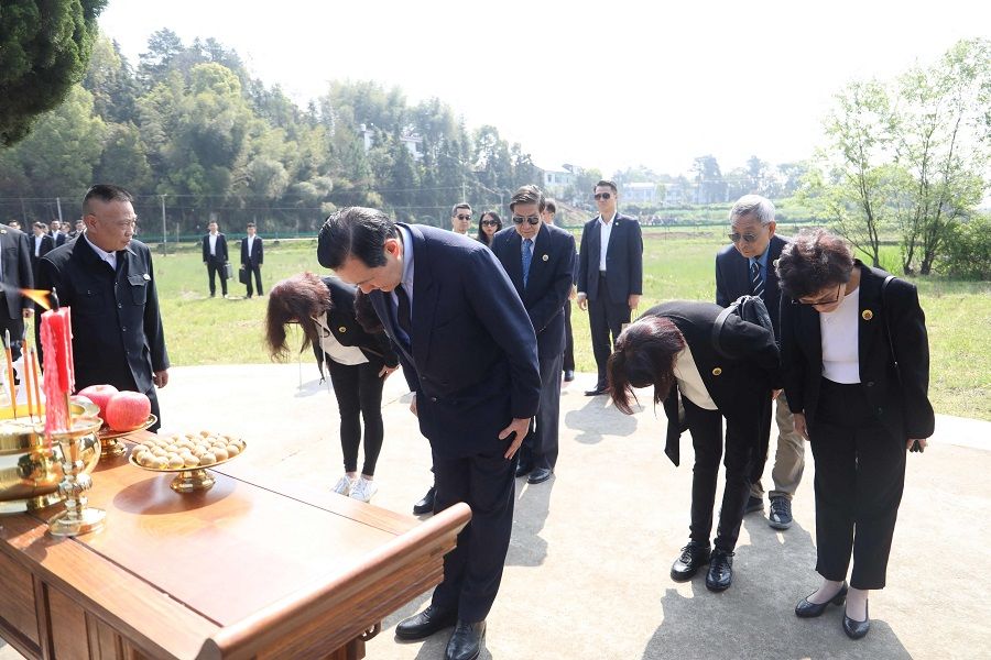 This handout picture taken and released by Taiwan's former President Ma Ying-jeou's office on 1 April 2023 shows former Taiwan President Ma Ying-jeou (centre) and his sisters paying their respects at their family's tomb in Xiangtan, Hunan province, China. (Handout/Ma Ying-jeou's office/AFP)