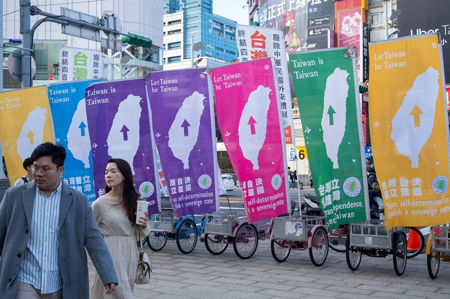 People walk past pro-independence flags at the Ximen District in Taipei, Taiwan, on 3 February 2024. (Sam Yeh/AFP)