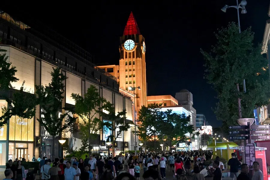 People walk along Wangfujing Avenue in Beijing, China, on 22 August 2024. (Adek Berry/AFP)