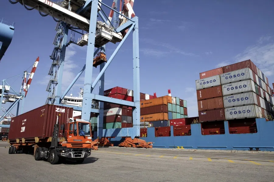 A truck removes a Zim-branded shipping container during the unloading of a cargo vessel at the Port of Haifa in 2011. In 2015, the Shanghai International Port Group entered into an agreement to build and operate a new port in Haifa for the next 25 years (Ariel Jerozolimski/Bloomberg)