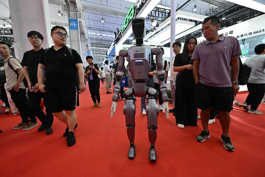 People look at a robot during an exhibition as part of the 2025 World Robot Conference in Beijing, China, on 8 August 2025. (Adek Berry/AFP)