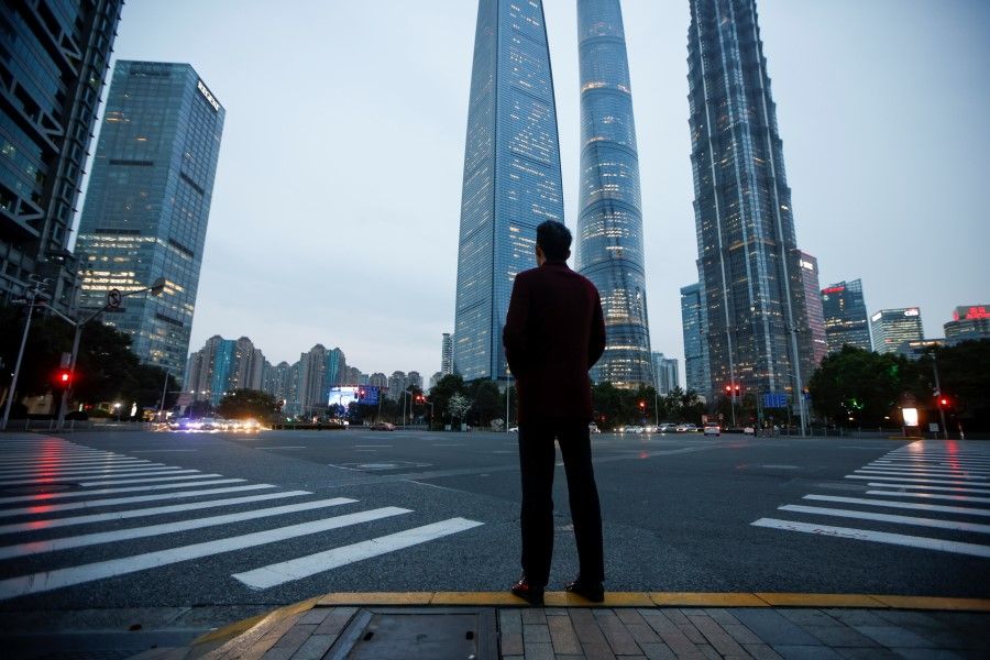 A man stands at a crossroads in Lujiazui financial district in Pudong, Shanghai, China, 5 March 2021. (Aly Song/Reuters)