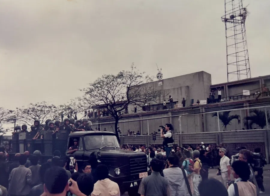 Rebel soldiers occupy a major television station and government troops arrive to suppress the mutiny as a military coup breaks out in the Philippines, January 1987.