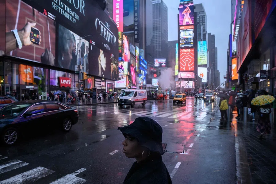 A pedestrian waits to cross a street during rain in Times Square New York on 26 September 2023. (Ed Jones/AFP)