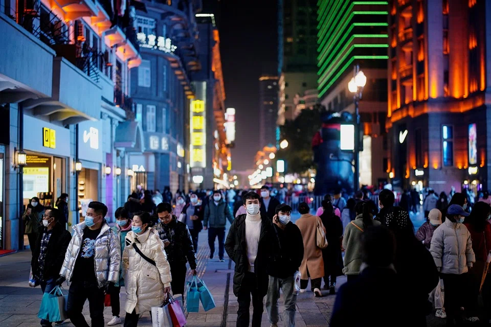 People wearing face masks are seen at a shopping area in Wuhan, Hubei province, China, 7 December 2020. (Aly Song/Reuters)