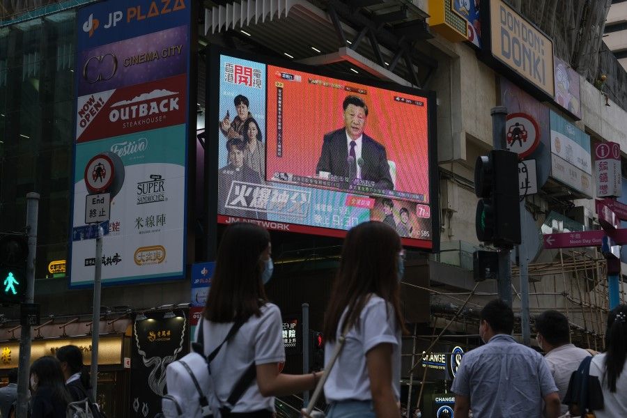 A news report on Chinese President Xi Jinping's speech in the city of Shenzhen is shown on a public screen in Hong Kong, China, on 14 October 2020. (Roy Liu/Bloomberg)