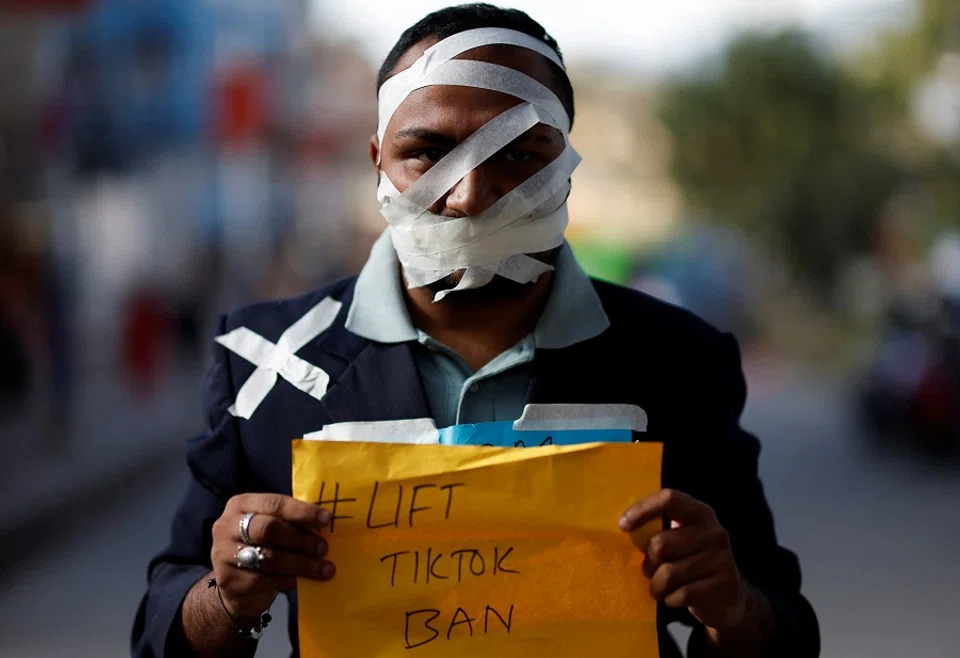 A protestor holds a placard as he takes part in a protest against the ban on TikTok in Kathmandu, Nepal, on 18 November 2023. (Navesh Chitrakar/Reuters)
