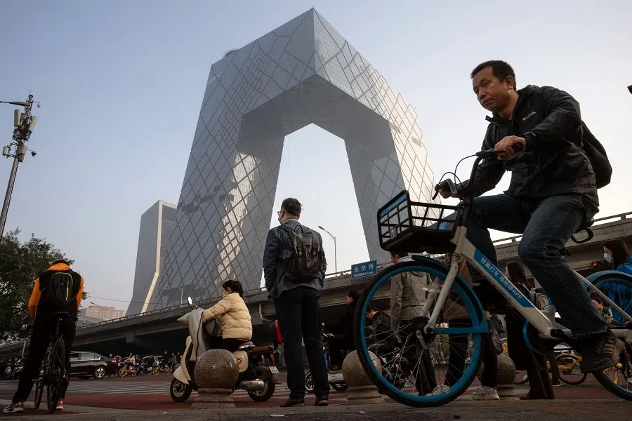 Morning commuters pass the CCTV tower in Beijing, China, on 30 October 2023. (Bloomberg)