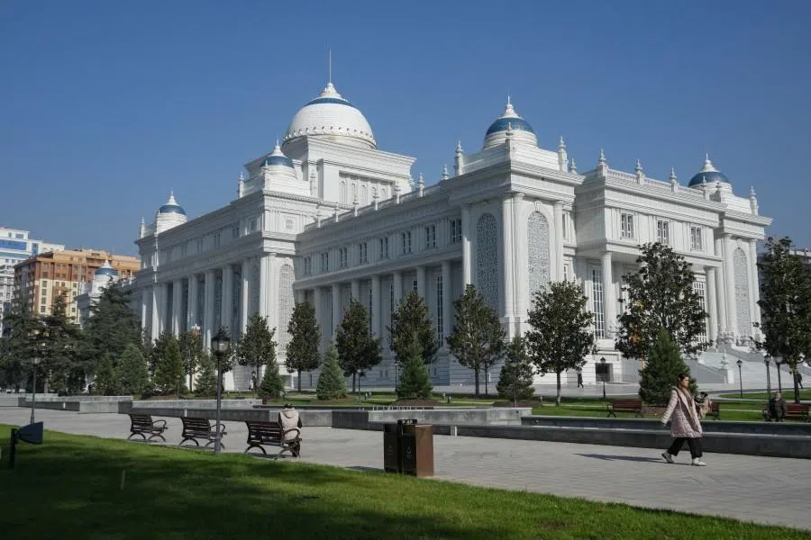 A woman walks past the parliament building in the Tajik capital Dushanbe on 2 December 2024.