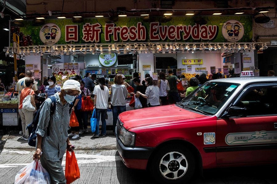 People shop for food at a market in Hong Kong, China, on 15 July 2022. (Isaac Lawrence/AFP)