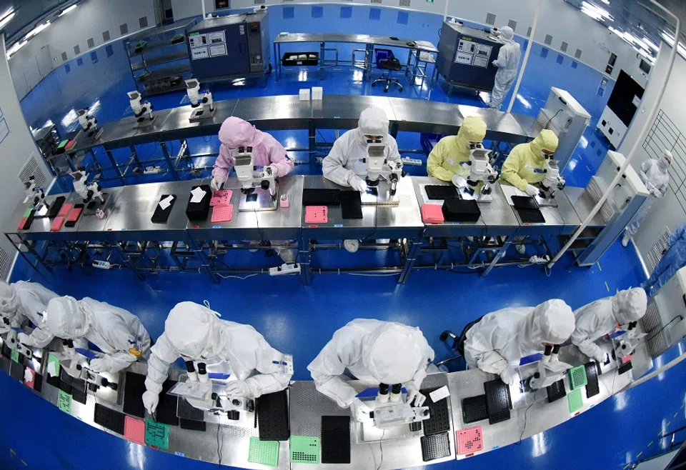Employees work on a production line manufacturing camera lenses for mobile phones at a factory in Lianyungang, Jiangsu province, China, 30 April 2019. (China Daily via Reuters)