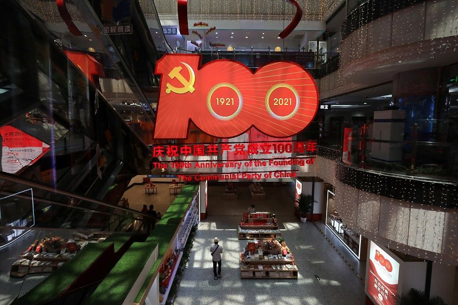 A giant decoration marking the 100th anniversary of the founding of the Communist Party of China is seen inside a bookstore in Beijing, China, 21 June 2021. (Tingshu Wang/Reuters)
