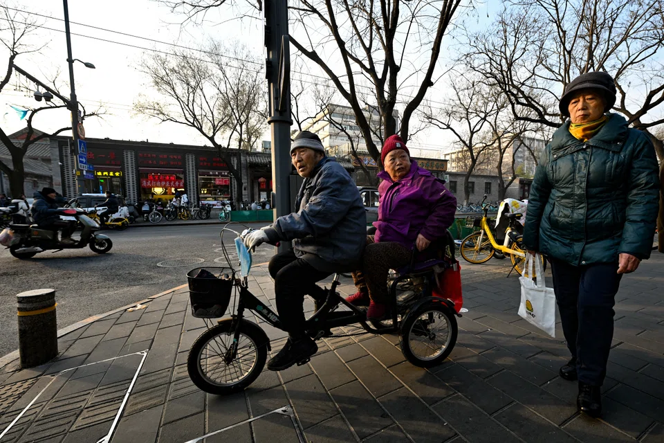 An elderly couple riding on a bicycle in Beijing, China, on 5 December 2023.  (SPH Media)