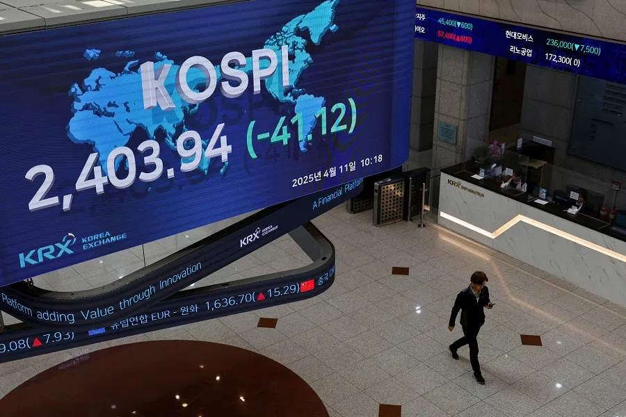 A man passes by a screen showing the Korea Composite Stock Price Index (KOSPI) at the Korea Exchange in Seoul, South Korea, on 11 April 2025. (Kim Soo-hyeon/Reuters)