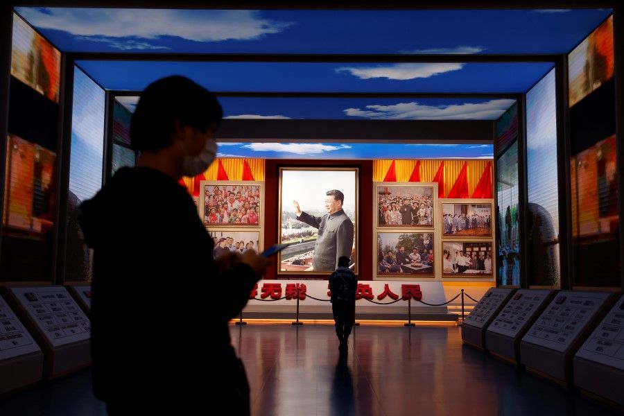 Visitors walk by images of Chinese President Xi Jinping displayed at the Museum of the Communist Party of China in Beijing, China, 11 November 2021. (Carlos Garcia Rawlins/Reuters)