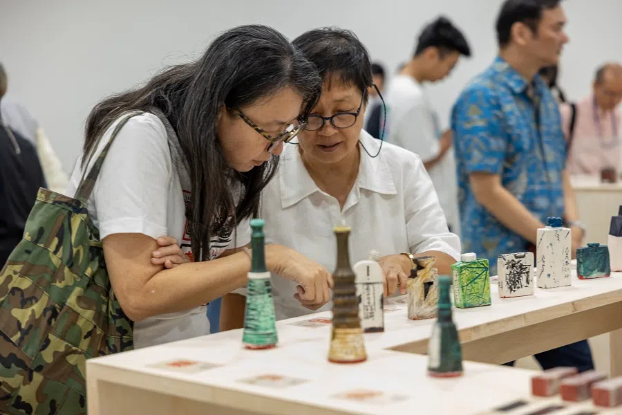 Visitors taking a closer look at the array of works.