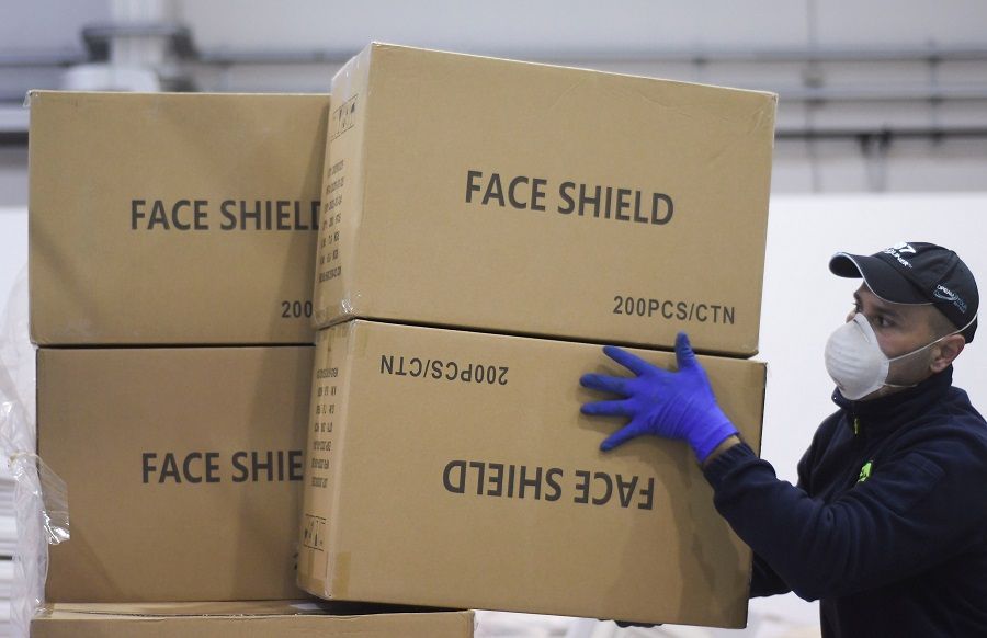 A worker piles up a shipment containing supplies of personal protective equipment at Bari airport after arriving from Guangzhou, China, to help the southern Italian region of Puglia combat the spread of the Covid-19 pandemic, on 7 April 2020. (Alessandro Garofalo/Reuters)