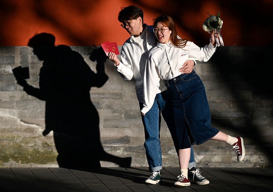 A couple poses for their wedding photoshoot along a road near the Forbidden City in Beijing, China, on 31 October 2022. (Wang Zhao/AFP)