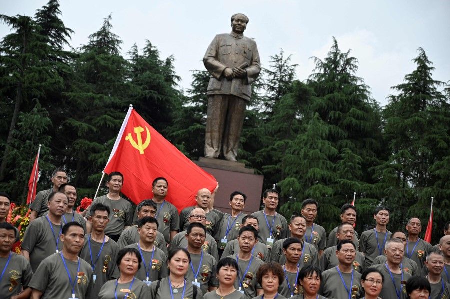 This photo taken on 27 May 2021 shows veterans posing for photographs in front of a bronze statue of late Chinese communist leader Mao Zedong at a square in Shaoshan, in China's central Hunan province. (Jade Gao/AFP)