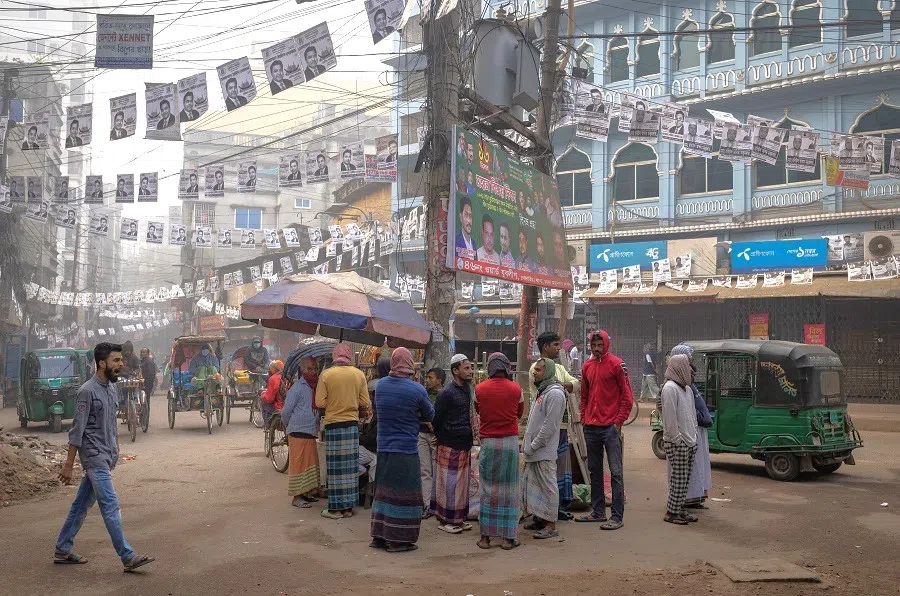 People stand along a street in Dhaka, Bangladesh, on 4 January 2024. (Adnan Abidi/Reuters)