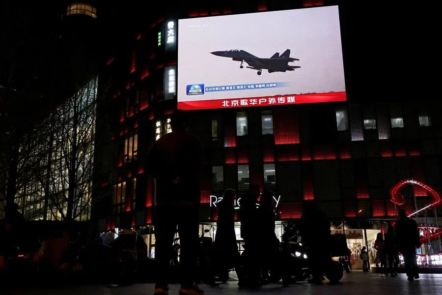 A military aircraft is seen on a giant screen showing news footage about joint army, navy, air and rocket forces drills around Taiwan by the Chinese People's Liberation Army (PLA), outside a shopping mall in Beijing, China, 1 April 2025. (Florence Lo/Reuters)