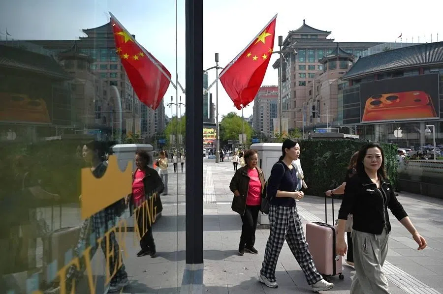 People walk outside a shopping mall in Beijing, China, on 7 October 2025.