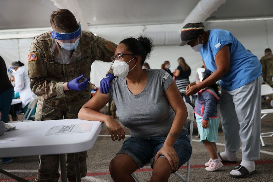 A woman receives the Covid-19 vaccine at the Miami Dade College North Campus on 9 March 2021 in North Miami, Florida. (Joe Raedle/AFP)