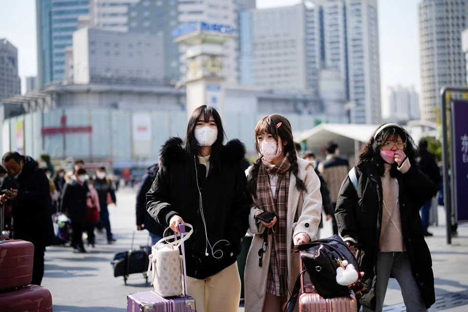 People walk with their luggage at a railway station during the annual Spring Festival travel rush ahead of the Lunar New Year, in Shanghai, China, 16 January 2023. (Aly Song/Reuters)