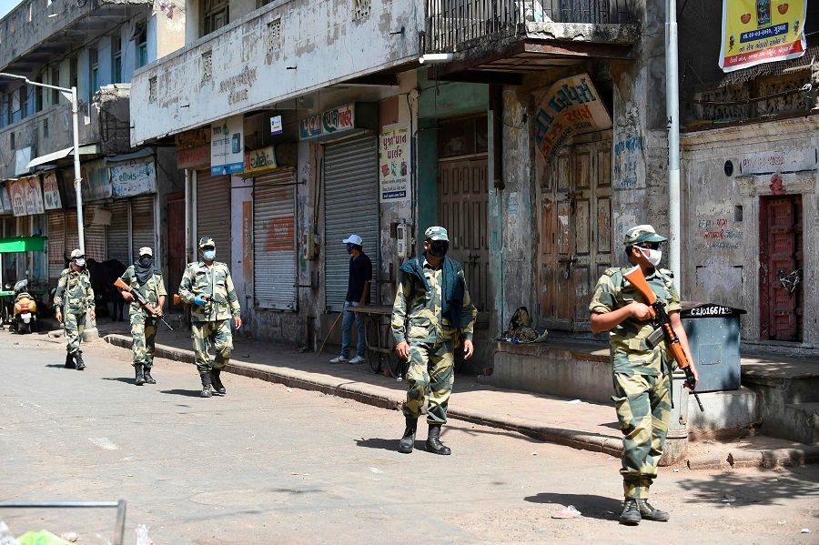 Paramilitary soldiers from the Border Security Force patrol a street during a government-imposed nationwide lockdown as a preventive measure against the Covid-19 coronavirus, in Ahmedabad, India, on 8 May 2020. (Sam Panthaky/AFP)