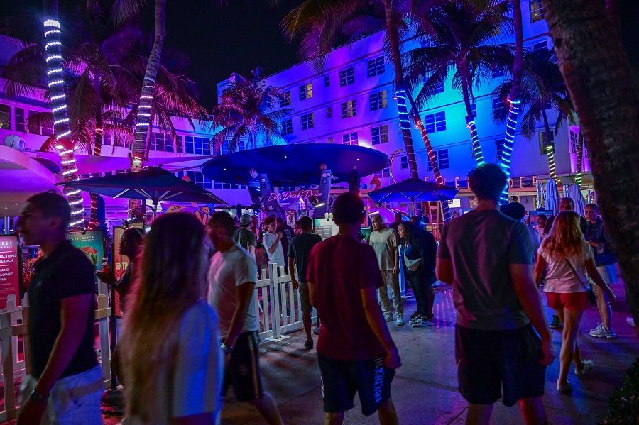 Revelers walk along Ocean Drive in Miami Beach on 8 March 2024. (Giorgia Viera/AFP)