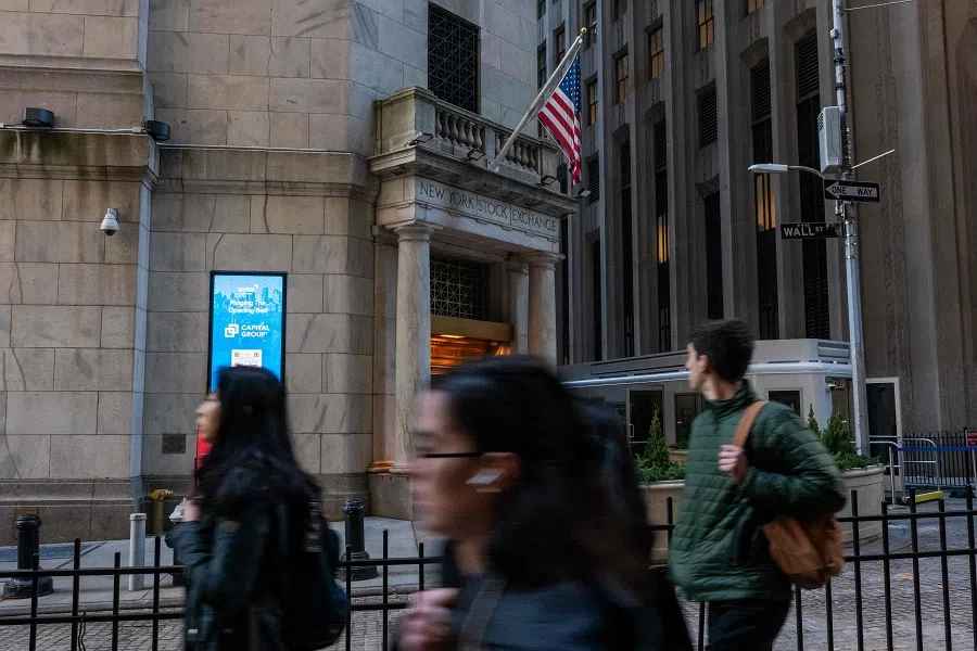 People walk along Wall Street by the New York Stock Exchange (NYSE) on 11 March 2025 in New York City. (Spencer Platt/AFP)