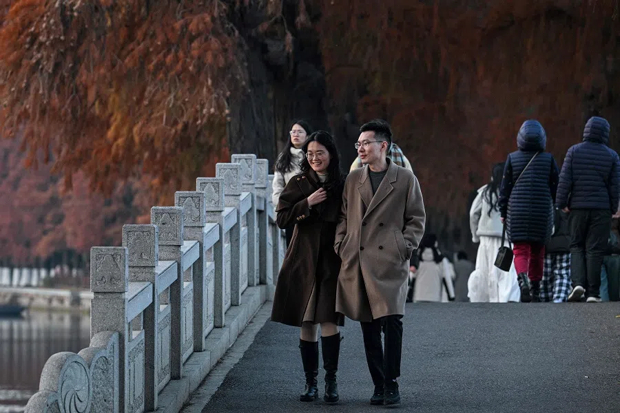 People walk along the East Lake in Wuhan, Hubei province, China, on 21 December 2024. (Hector Retamal/AFP)