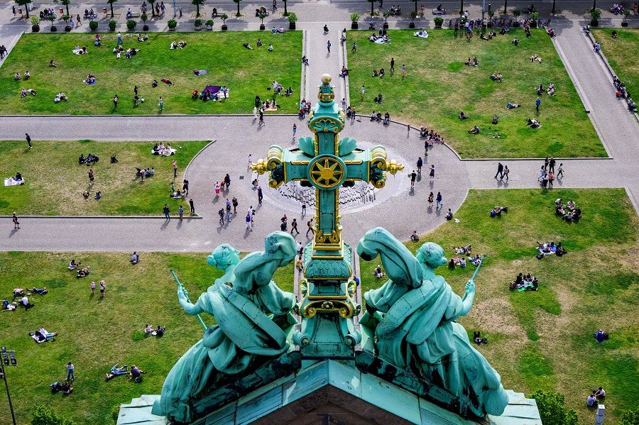 A view taken from the dome of the Berlin Cathedral shows people lying on the lawns of the Lustgarten in the German capital on 21 May 2023. (John MacDougall/AFP)