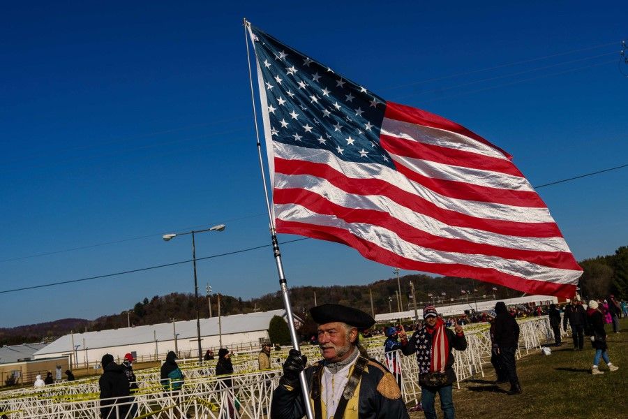A man holds a US flag at a rally in West Salem, Wisconsin on 27 October 2020. (Kerem Yucel/AFP)