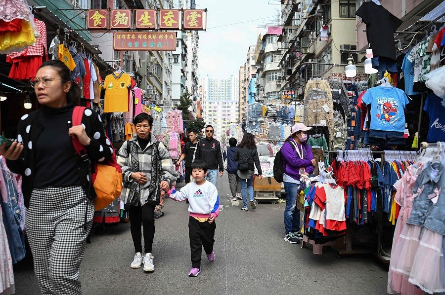 People walk through a market street in the Kowloon district of Hong Kong on 27 February 2024. (Peter Parks/AFP)