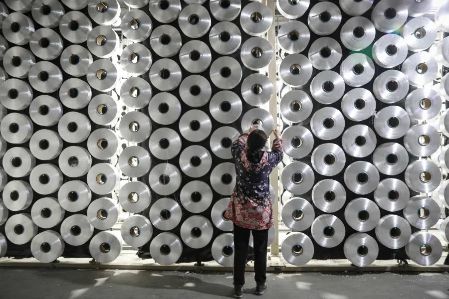 An employee works at a textile factory in Hangzhou, in eastern China's Zhejiang province on 17 March 2024. (AFP)