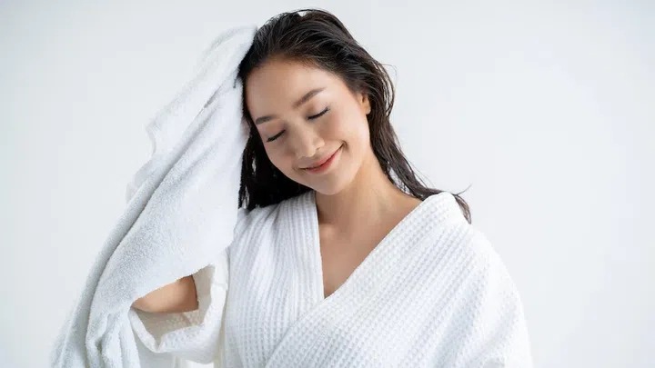 Asian woman   using a dry towel to dry their hair.after showering
