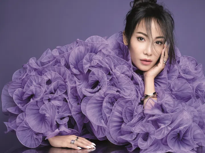 Ruffled cropped jacket, H&M x Iris Apfel. B.zero1 yellow gold bracelet, B.zero1 yellow gold bangle bracelet, B.zero1 white gold bangle, B.zero1 5-band 20th Anniversary white gold ring, B.zero1 New Classic 3-band yellow gold ring, and B.zero1 5-band 20th Anniversary white gold ring with pave diamonds, Bvlgari