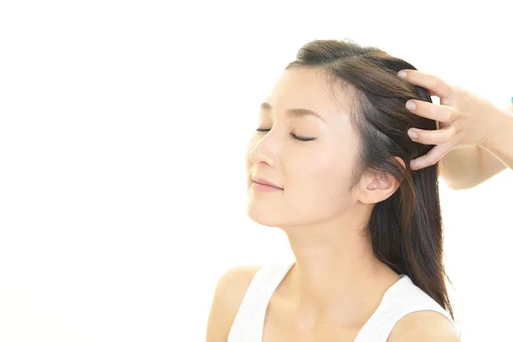 Woman in spa salon receives head massage