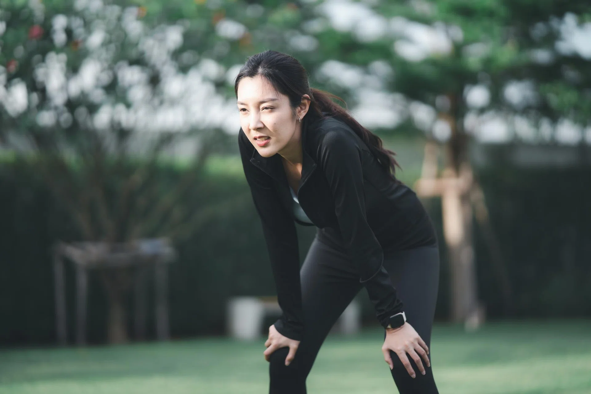 Young Asian women sports tired after exercise and runs at public park.