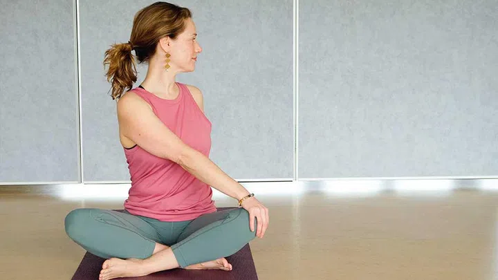 To improve your digestion, get into a seated side twist yoga pose